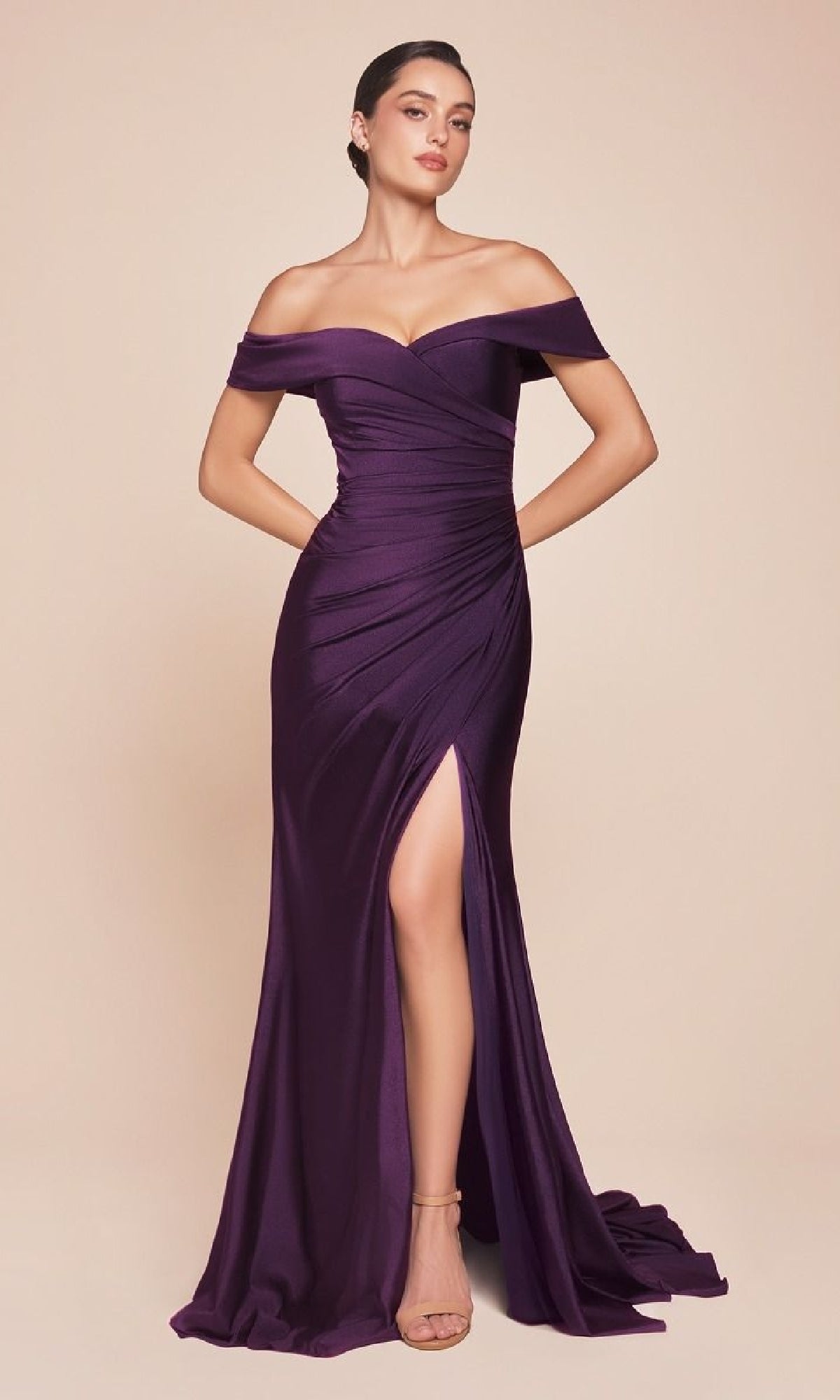 A woman poses elegantly in the Ladivine CD790, an off-the-shoulder long prom dress in deep purple satin featuring a ruched bodice and high slit, set against a neutral background.